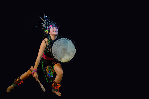 nuori nainen Teotihuacana, Xicalanca - Toltec mustalla taustalla, perinteinen pukeutuminen tanssi sulkia ja rumpua
 - Valokuva, kuva