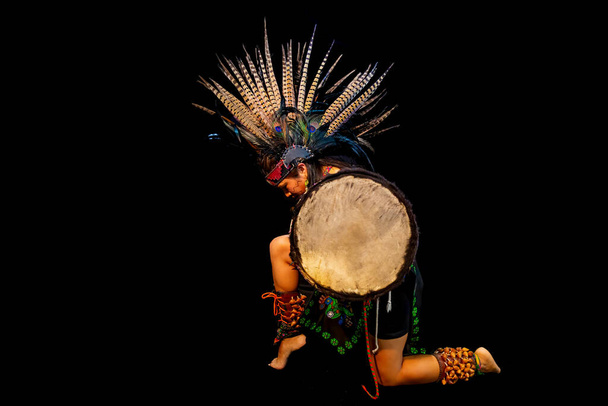 jeune femme Teotihuacana, Xicalanca Toltec en arrière-plan noir, avec la danse de robe traditionnelle avec un dispositif à plumes et tambour
 - Photo, image