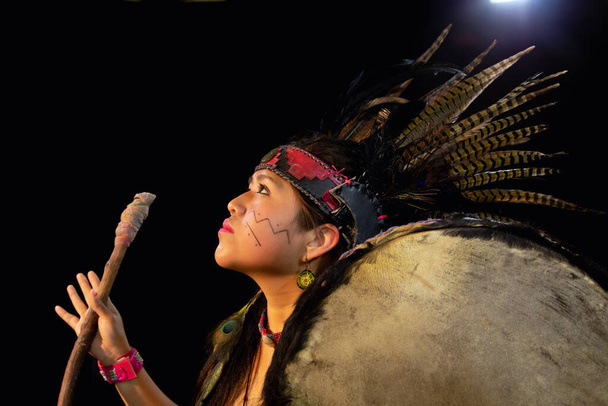 primer plano de la joven Teotihuacana, Xicalanca - Tolteca en fondo negro, con baile de vestir tradicional con una trampas con plumas y tambor
 - Foto, imagen