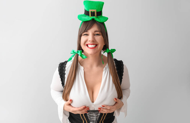 Funny young woman on light background. St. Patrick's Day celebration - Photo, Image