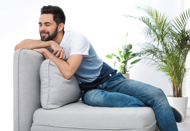 Young man relaxing on couch at home - Foto, imagen