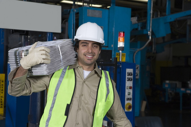 Man carrying newspapers in factory - Foto, Imagem