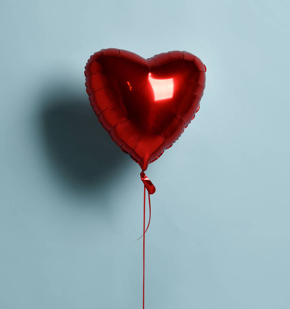 Metallic foil single red heart balloon object for birthday party or valentines day on pastel color light blue - Φωτογραφία, εικόνα