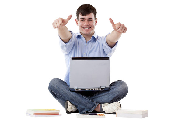 young,handsome man with computer shows thumbs up. isolated on white background. - Foto, immagini