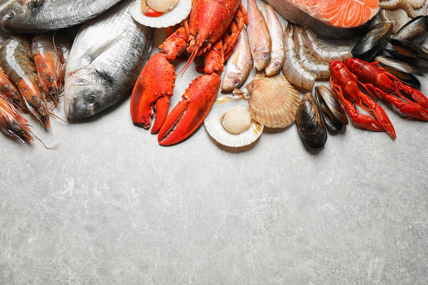 Fresh fish and seafood on marble table, flat lay. Space for text - Foto, afbeelding