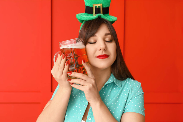 Funny young woman with beer on color background. St. Patrick's Day celebration - Foto, Imagen