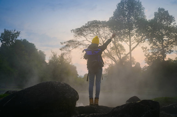 kobieta trekking samotnie na jeziorze lasu góry z ciepłą wodą źródlaną płynącą nad jeziorem rano, radośnie w ruchu świeżo rano - Zdjęcie, obraz