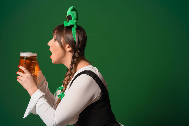 Lustige junge Frau mit Bier auf farbigem Hintergrund. St. Patrick 's Day Feier - Foto, Bild