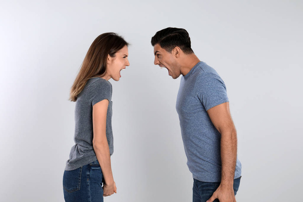 Couple quarreling on light background. Relationship problems - Foto, immagini