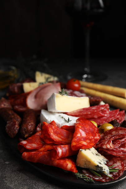 Tasty salami with other delicacies served on grey table - Фото, зображення