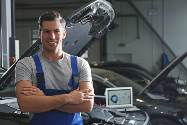 Mechanic near automobile in service center, space for text. Car  - Foto, imagen