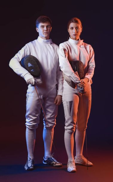 Toned photo of young fencers on dark background - Foto, Bild