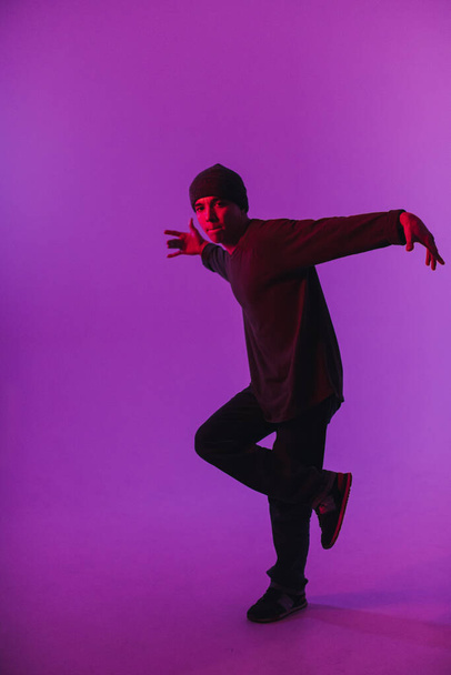 Young Man in a Jumper Dancing Contemporary Dance in Studio (em inglês). Breakdancing. Cartaz da Escola de Dança. Espaço Copiar. Anúncio da competição. Fundo rosa e azul. - Foto, Imagem