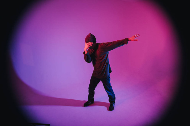 Young Man in a Jumper Dancing Contemporary Dance in Studio. Breakdance. Poster della scuola di danza. Ricevuto. Annuncio gara di battaglia. Sfondo rosa e blu. - Foto, immagini