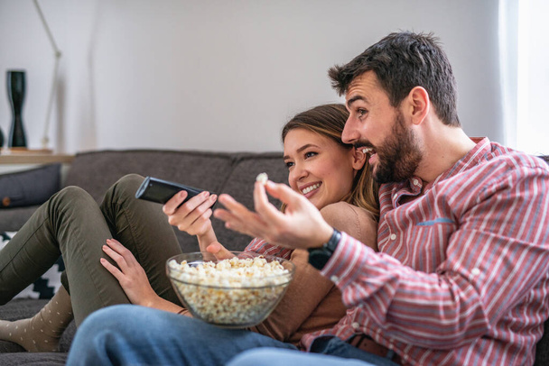 Happy couple preparing to watch a movie at home - Foto, imagen