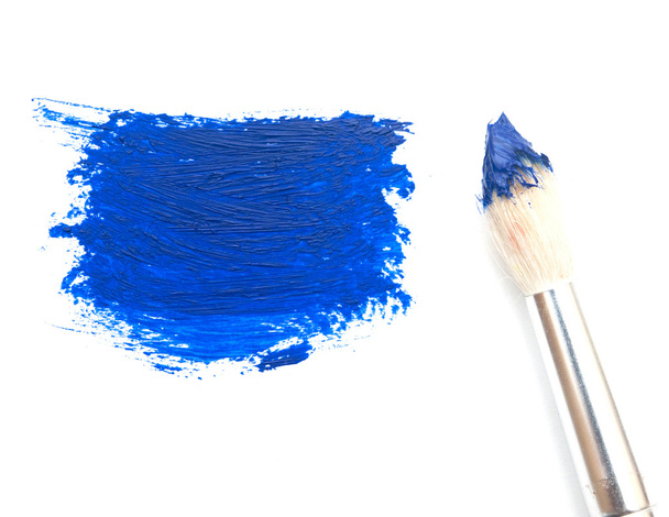 kunstenaar borstel met blauwe verf op een witte achtergrond - Foto, afbeelding