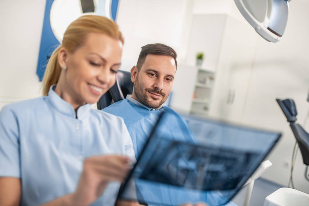 Dentista y paciente mirando a rayos X
 - Foto, imagen