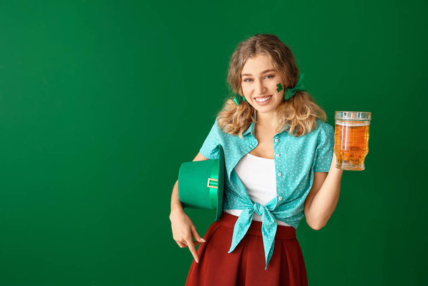 Young woman with beer on color background. St. Patrick's Day celebration - Photo, Image