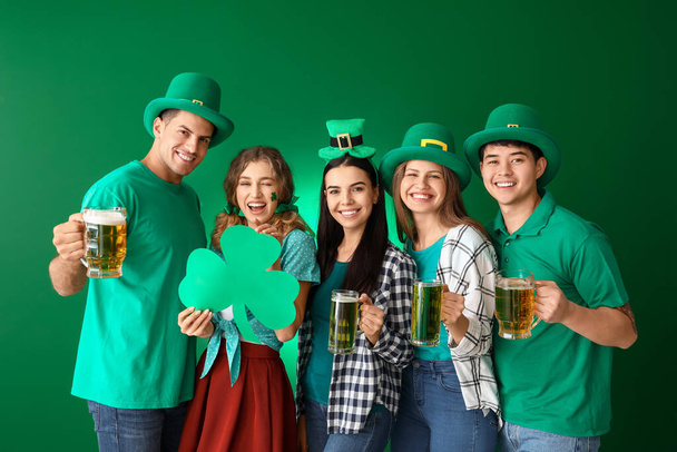 Friends with beer and clover on color background. St. Patrick's Day celebration - Photo, Image