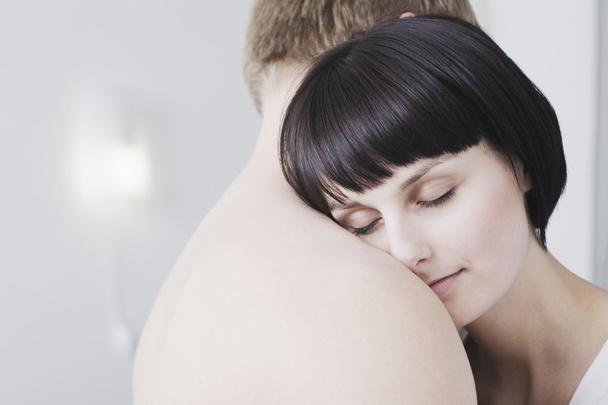Woman leans on man's naked shoulder eyes closed - Photo, Image