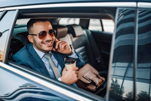 Attractive young businessman in a car - 写真・画像