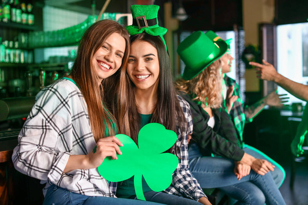 Young women celebrating St. Patrick's Day in pub - Foto, afbeelding