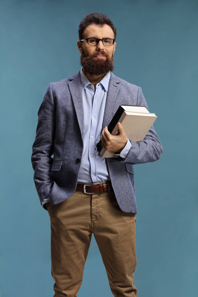 Bearded man with glasses holding books - Foto, afbeelding