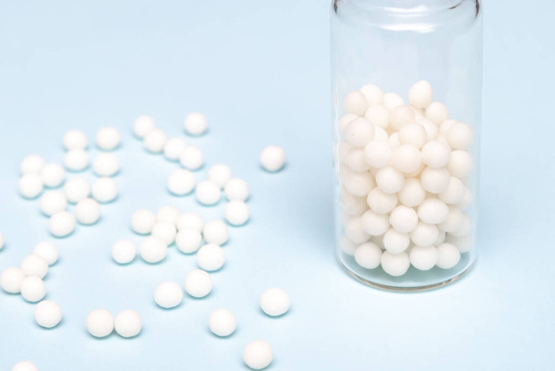 Classical homeopathy pills, white globules in a glass bottle close up, alternative medicine concept - 写真・画像