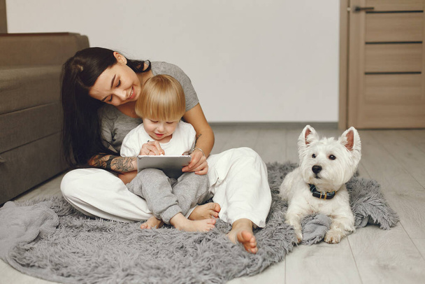 Mother and little son fun at home with dog - Фото, зображення