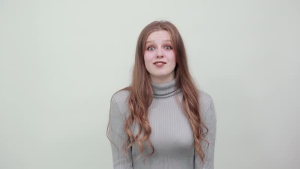 mujer en suéter con expresión divertida en la cara presenta las manos se ve sorprendido
 - Metraje, vídeo