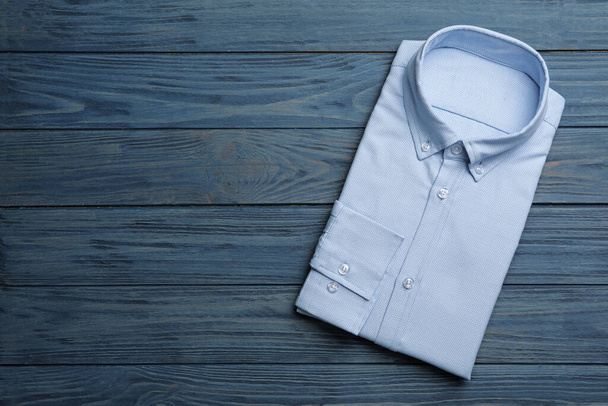 Male stylish light blue shirt on wooden background, top view. Sp - Foto, Imagem