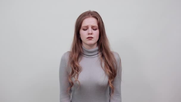 ruda kobieta w szarym swetrze z bólem głowy trzyma ręce na głowie - Materiał filmowy, wideo