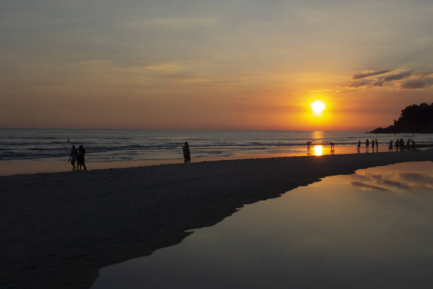 Activités humaines à la plage au coucher du soleil
 - Photo, image