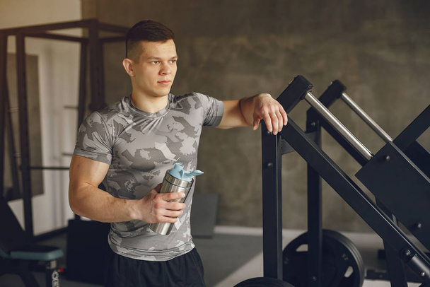 A handsome man is engaged in a gym - Foto, afbeelding