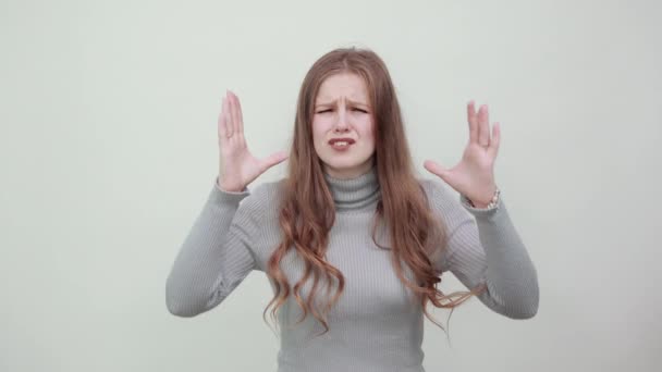 Frau im grauen Pullover reagiert gereizt, ein wütender Gesichtsausdruck wedelt mit den Händen - Filmmaterial, Video