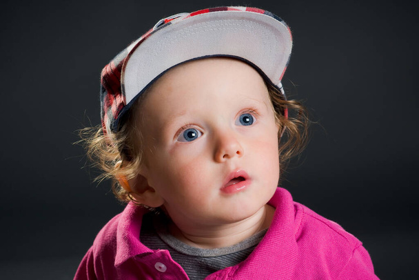 casual cool young child with hat in front of a gray background - Fotografie, Obrázek