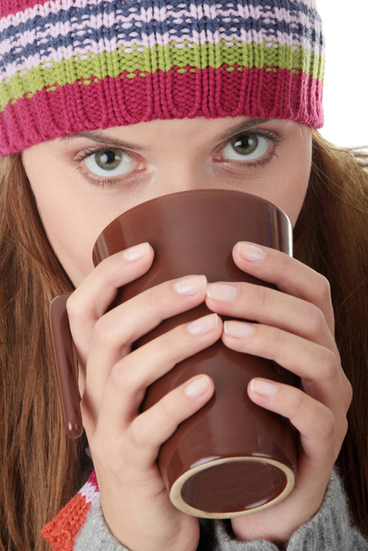 Young woman in winter hat with cup of hot chocolate or coffee or tea  - Foto, imagen