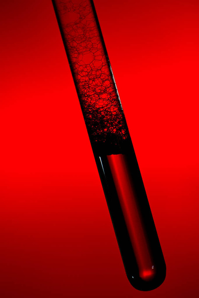 test tube of glass filled with liquid and foam - Foto, afbeelding