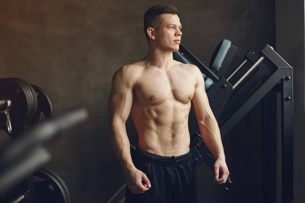 A handsome man is engaged in a gym - Fotó, kép