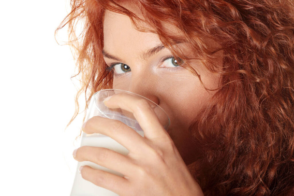 Young beautiful woman drinking milk, isolated on white  - Valokuva, kuva