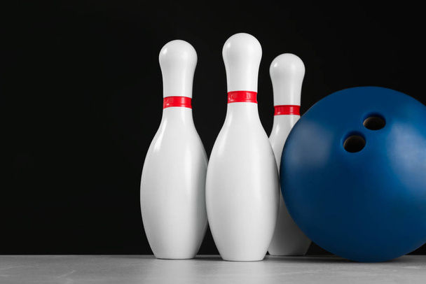 Blue bowling ball and pins on light grey marble table - 写真・画像