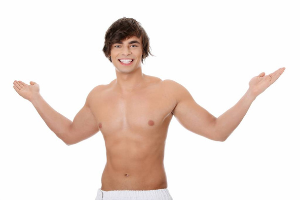 Handsome, happy young man with the towel around his waist. Isolated on white  - Φωτογραφία, εικόνα