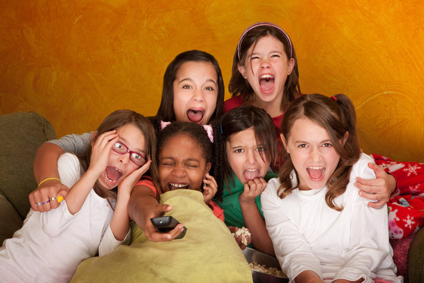 Six girls watching a movie scream at a sleepover - Fotoğraf, Görsel