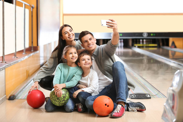Happy family taking selfie in bowling club - Foto, Bild