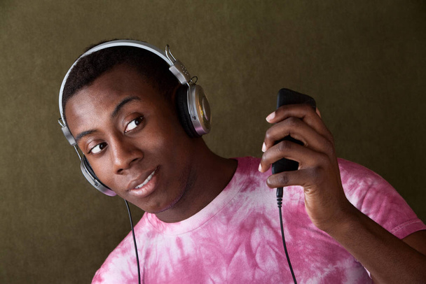 ヘッドフォンで彼のmp3プレーヤーを一目でハンサムなアフリカ系アメリカ人 - 写真・画像