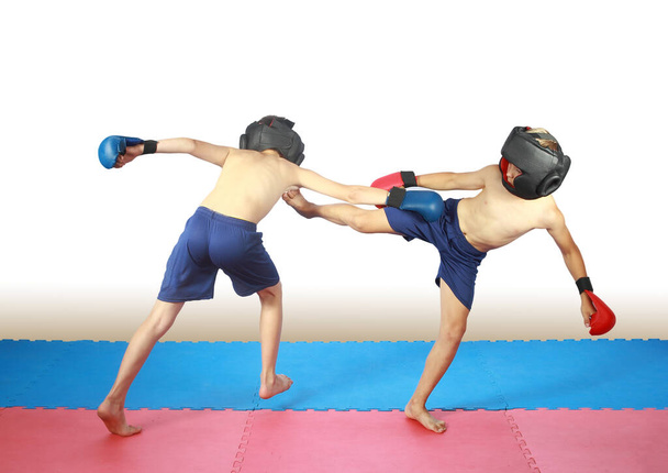 В шлемах и накладках тренируются два спортсмена ударами по мячу
 - Фото, изображение