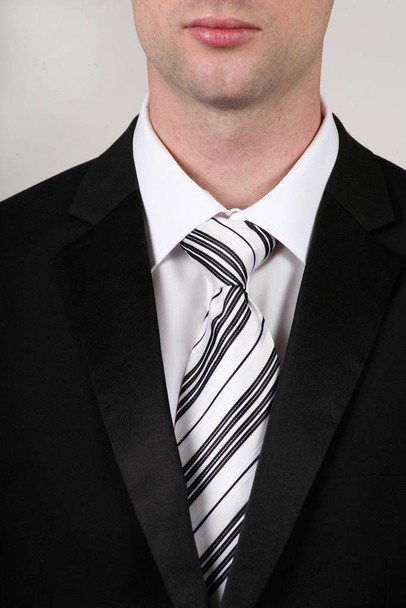 portrait of businessman wearing a black suit wearing white shirt and black white tie - Valokuva, kuva
