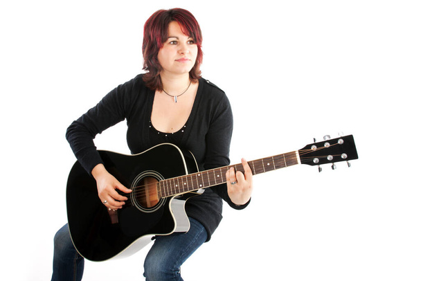 woman sitting with black guitar playing - Photo, Image