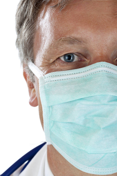 closeup of the face of a doctor wearing surgical masks to protect against ehec. isolated on white background. - Photo, Image
