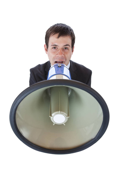 closeup of a young businessman brllt.freigestellt loudly into megaphone on white background.  - Фото, зображення